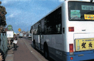 Photo image:Bus and bus stop next to parking lots